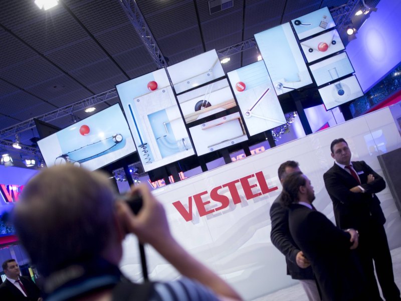 Vetsel Logo mit TVs im Hintergrund auf Messe