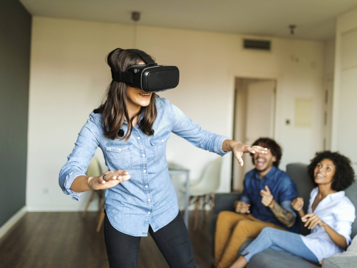 Frau mit einer VR-Brille und Freunden.