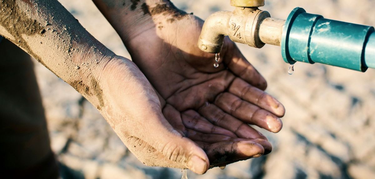 Trockene Hände unter einem Wasserhahn