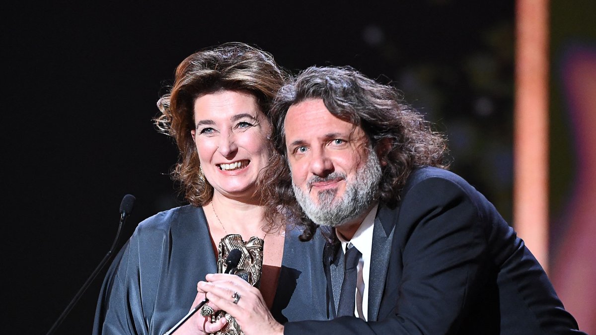 Die französischen Filmproduzenten Olivier Delbosc und Sidonie Dumas nehmen den Preis als "Bester Film" für "Illusions perdues" entgegen.. © BERTRAND GUAY/AFP via Getty Images