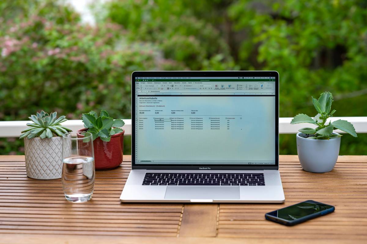 Laptop mit Excel auf Gartentisch im Freien