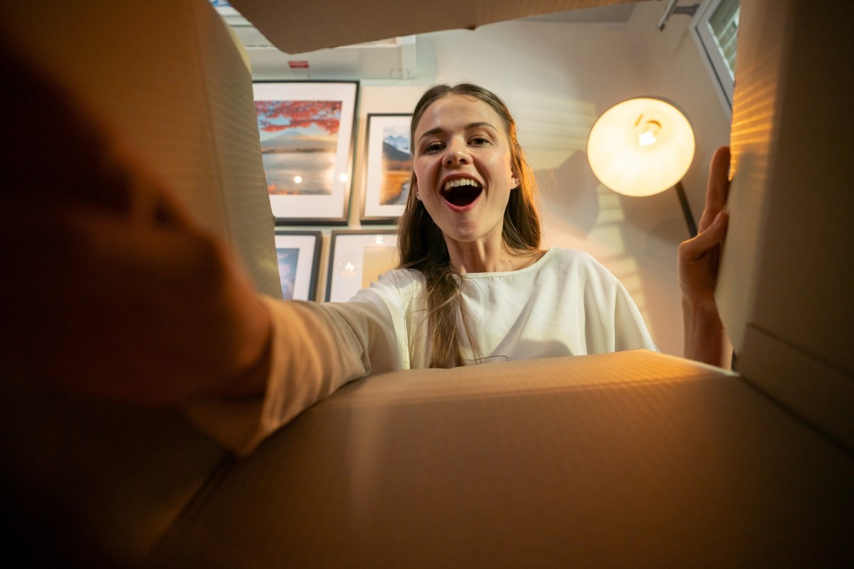 Frau schaut freudig in ein Paket