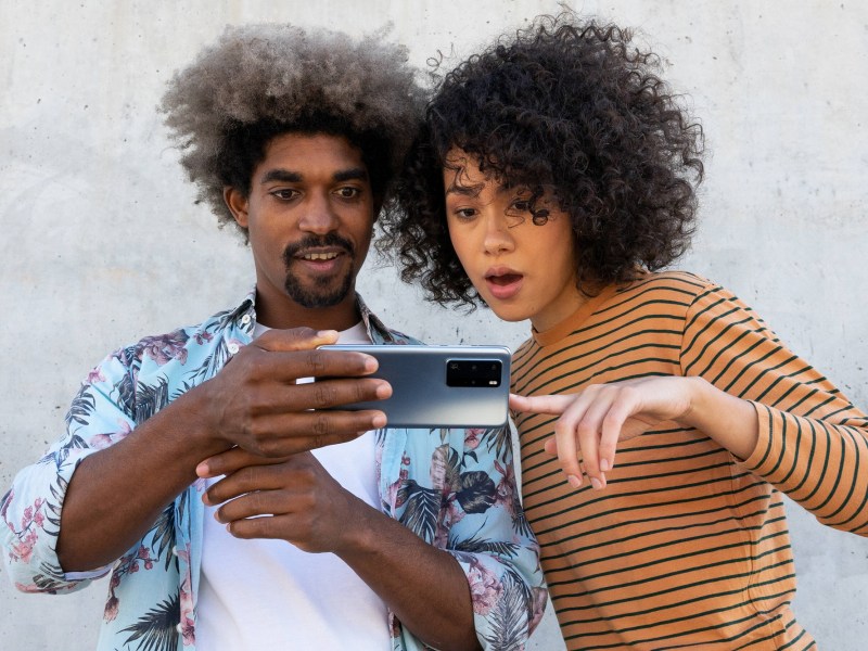 Mann und Frau schauen verdutzt auf Smartphone