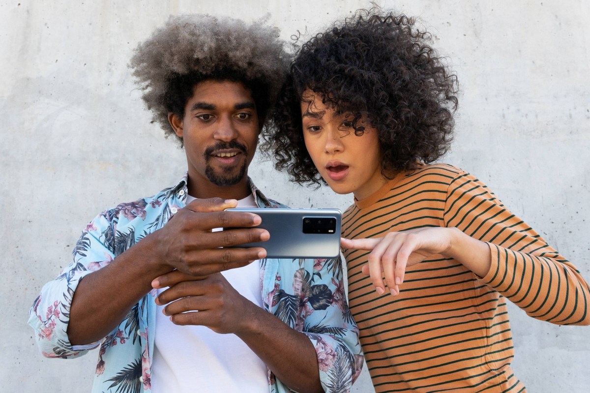 Mann und Frau schauen verdutzt auf Smartphone