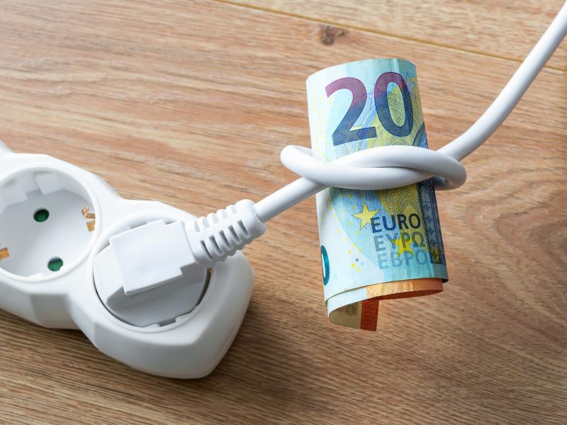 Stecker in der Steckdose und ein 20-Euro-Schein