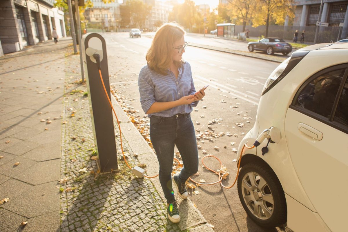 Frau lädt Elektroauto