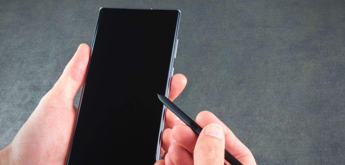 Mann hält ein Samsung Galaxy S22 Ultra mit Pen in der Hand.