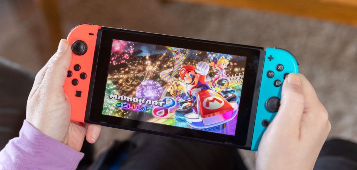 Person hält Nintendo Switch mit "Super Mario Kart 8 Deluxe".