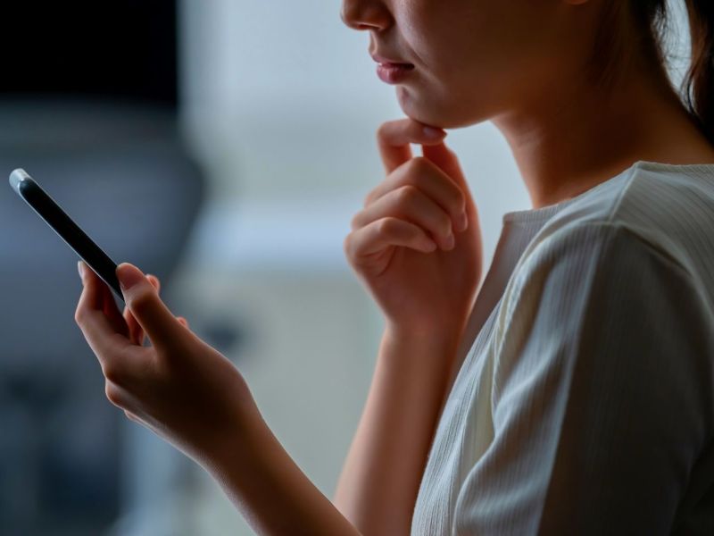 Frau blickt besorgt auf ihr Smartphone