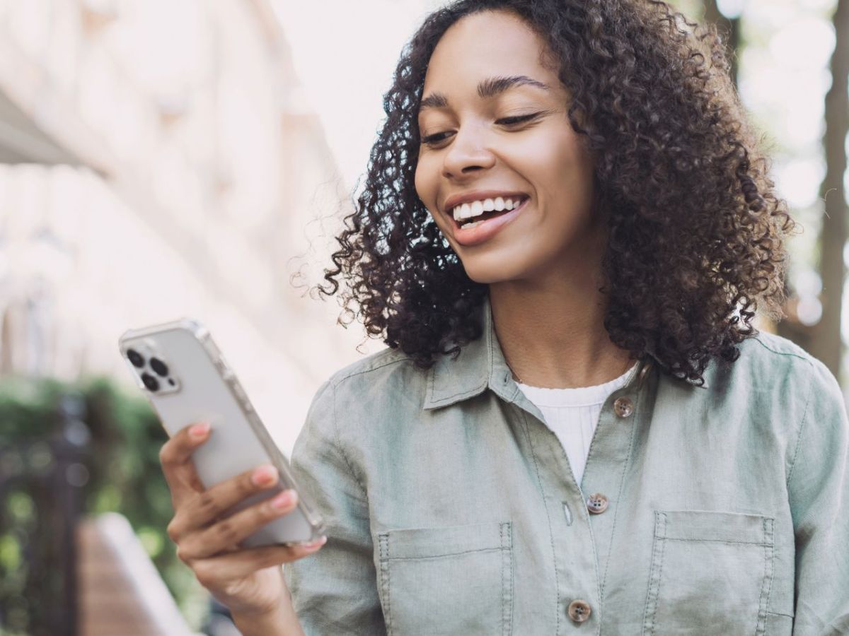 Frau hält herkömmliches, nicht-faltbares iPhone