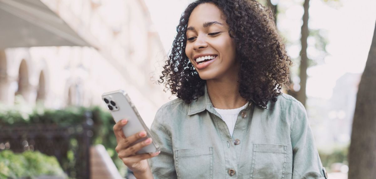 Frau hält herkömmliches, nicht-faltbares iPhone