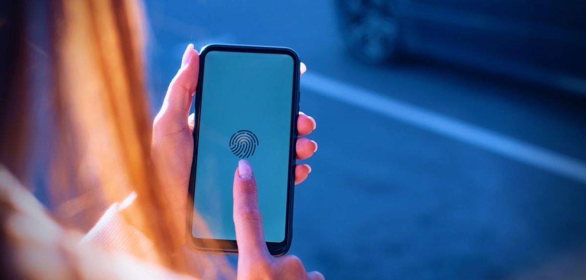 Frau mit Smartphone hält ihren Finger über das Display.