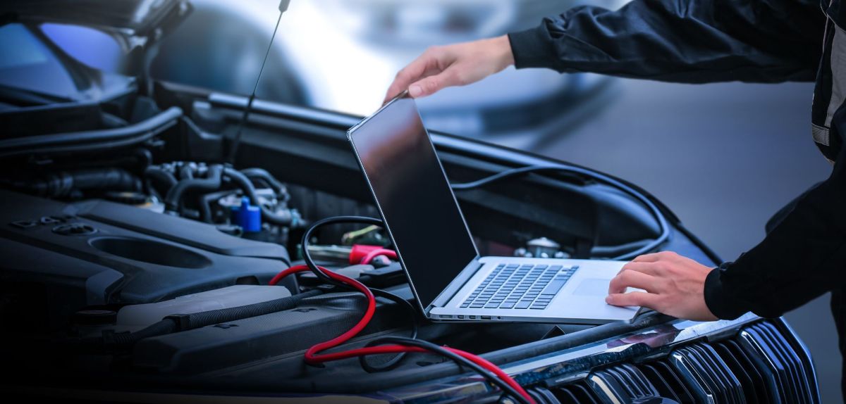 Laptop auf dem Motorraum eines Autos