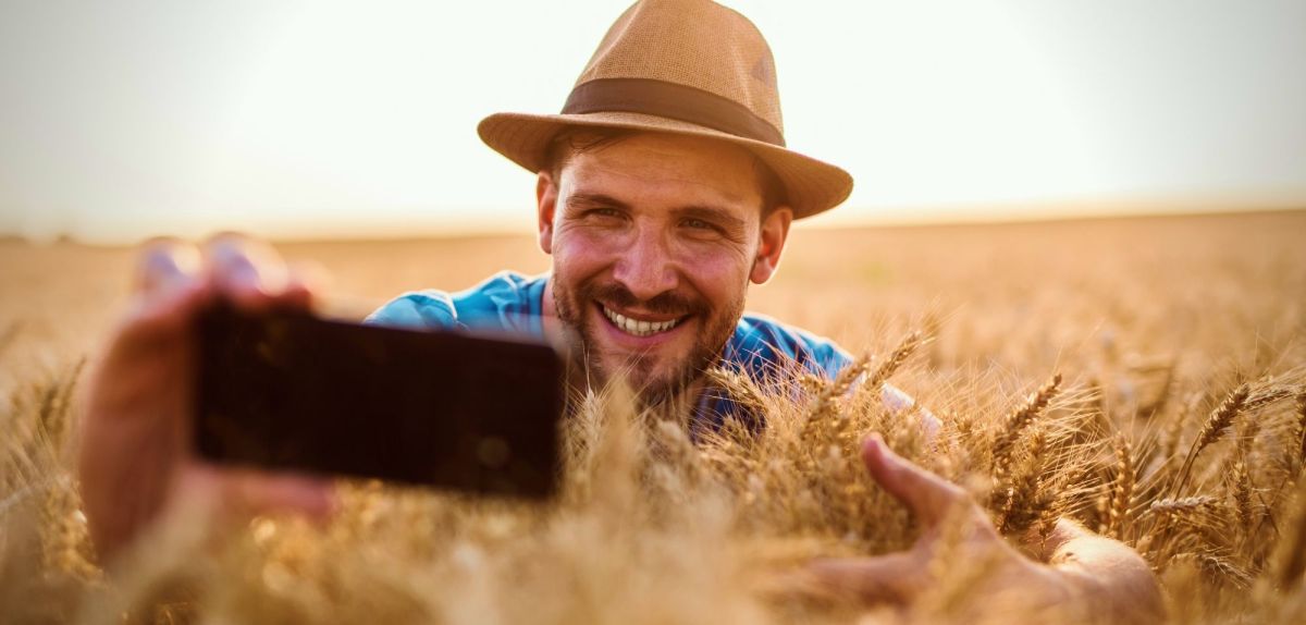 Mann macht Foto im Feld