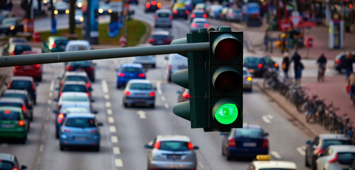 Grüne Ampel über einer stark befahrenen Straße