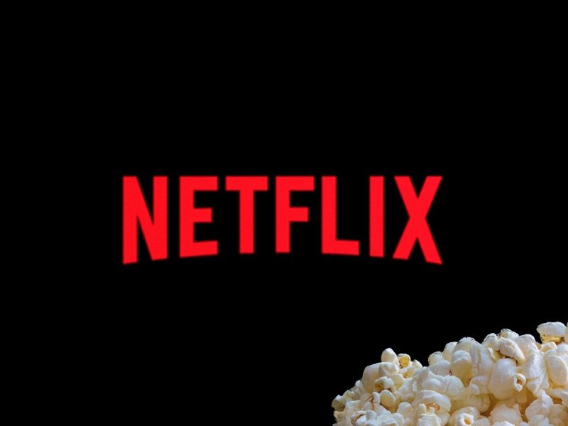 Netflix-Logo auf einem TV, davor Popcorn.