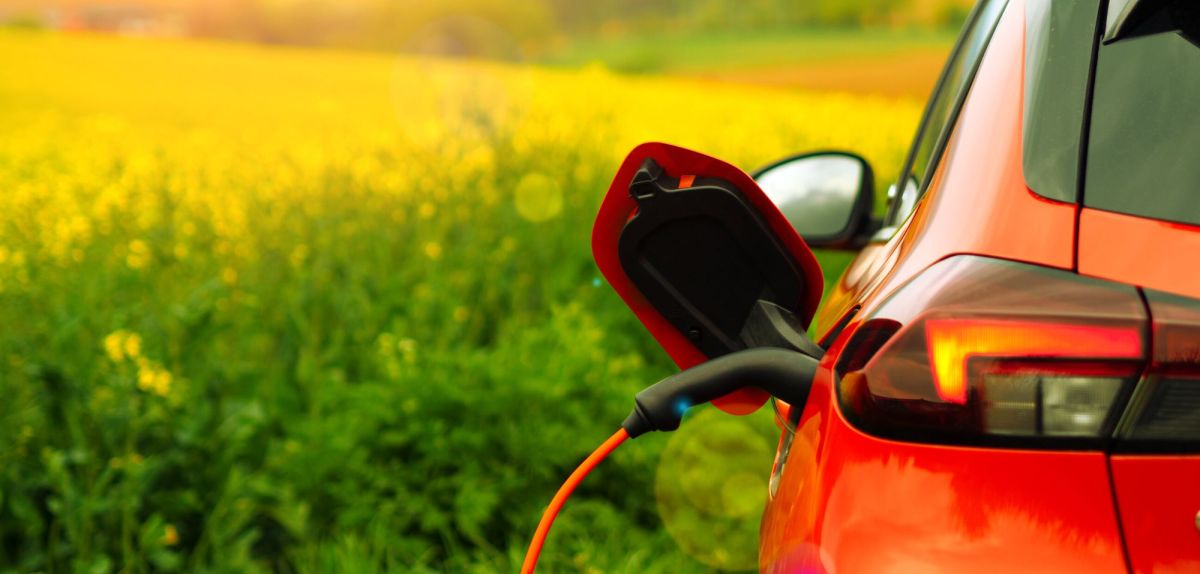 Ein Elektroauto wird bei gutem Wetter aufgeladen.