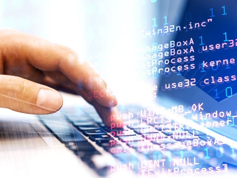 Hand auf Tastatur, darüber Grafiken von Code-Zeilen.