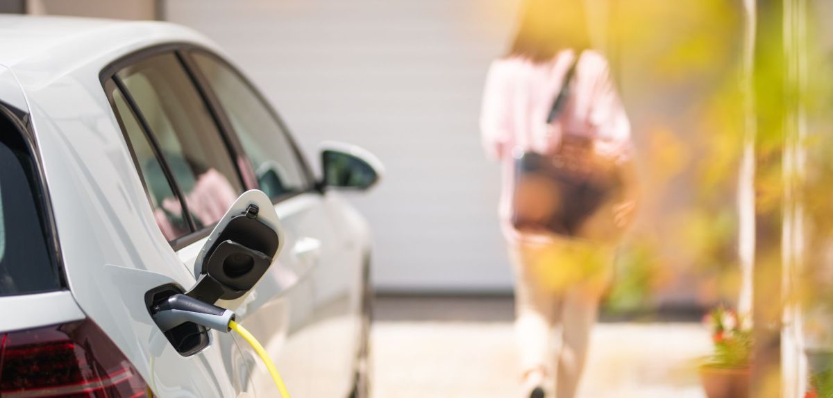 Frau entfernt sich von einem Elektroautos