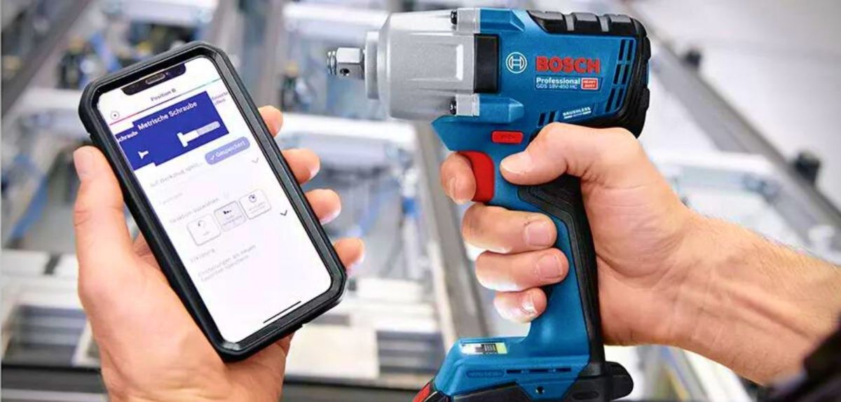 Bosch Professional AKKU-BOHRSCHRAUBER GSR 18V-110 C neben einem Smartphone