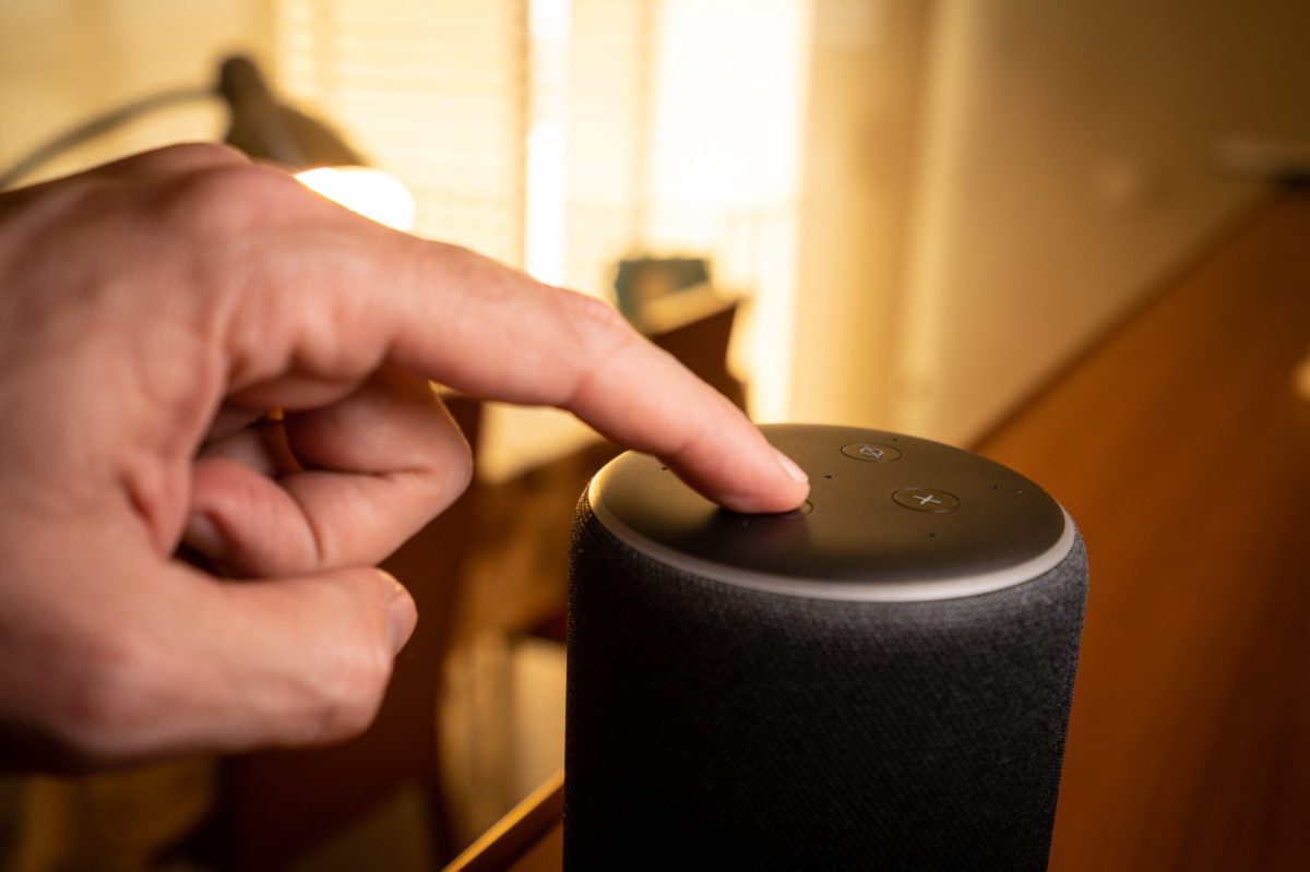 Hand tippt auf Amazon Echo.