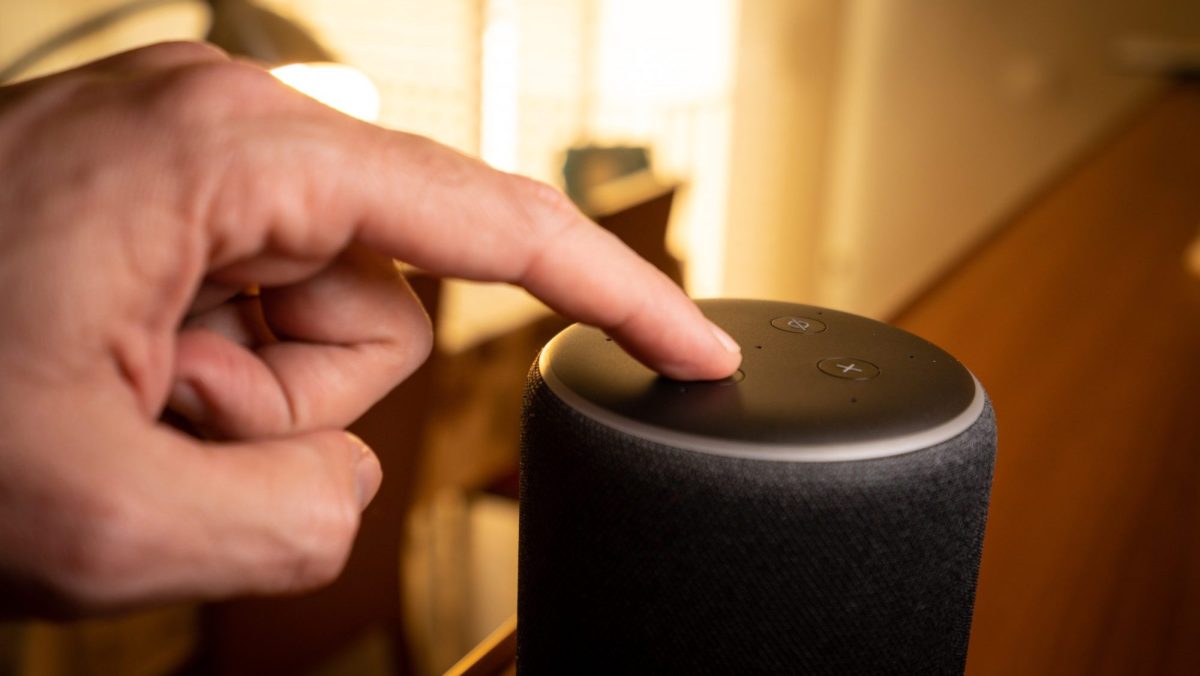Hand tippt auf Amazon Echo.