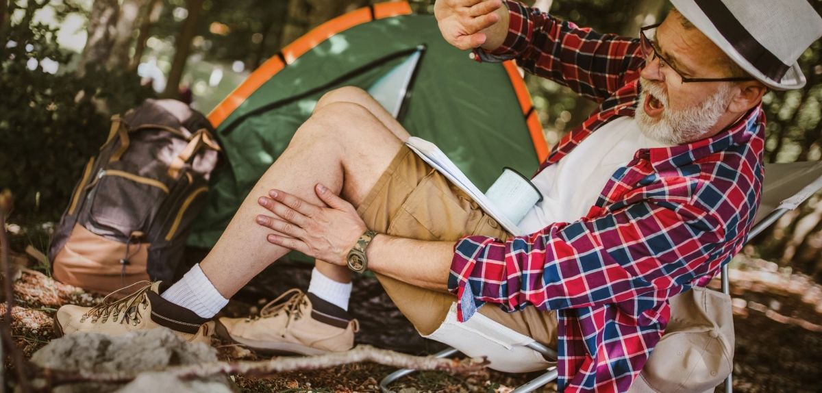 Camper schägt eine Mücke