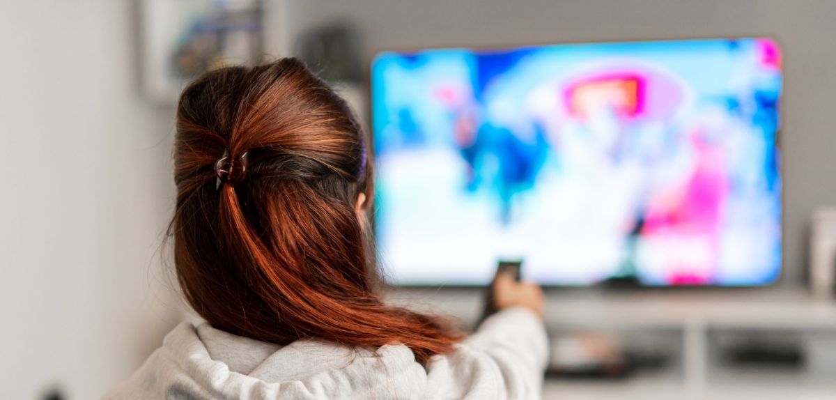 Frau schaut auf einen gebrauchten Fernseher.