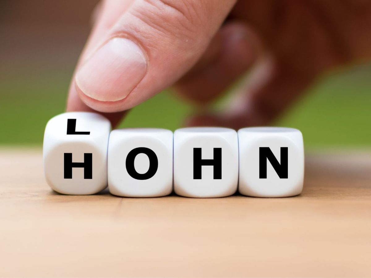 Würfel zeigen das Wort "Lohn" und "Hohn"