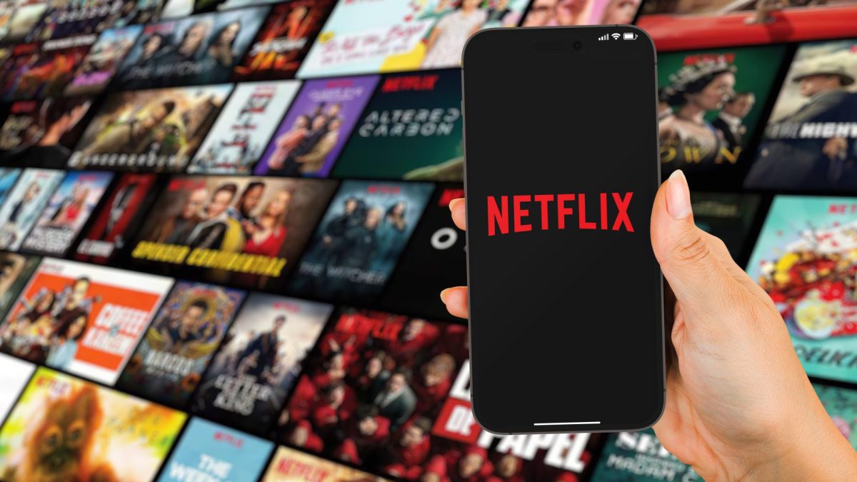 Eine Frau hält ein Smartphone mit Netflix.