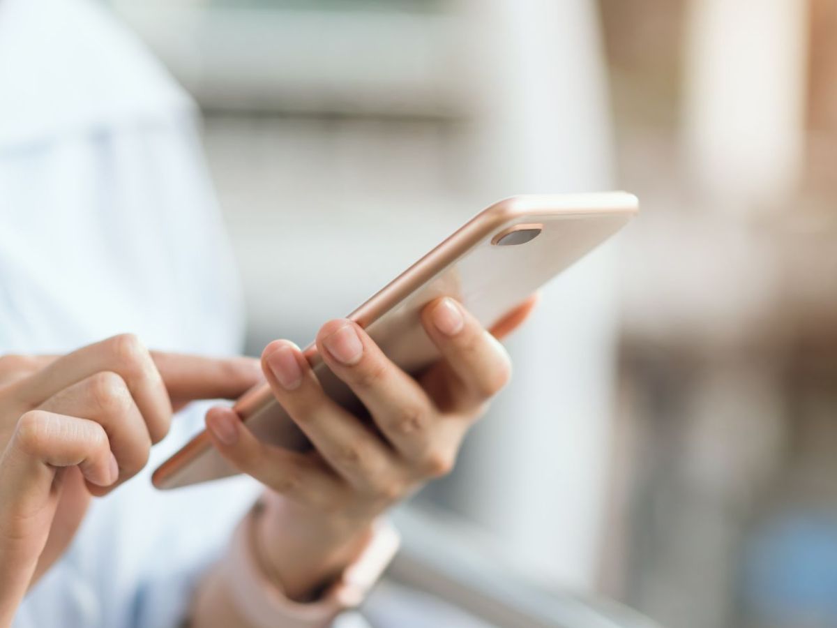 Frau hält ein Smartphone in der Hand.