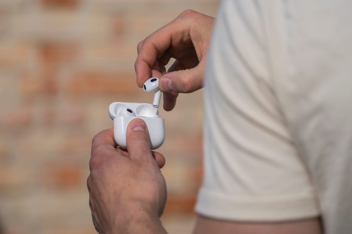 Mann steckt AirPods in ihre Halterung.