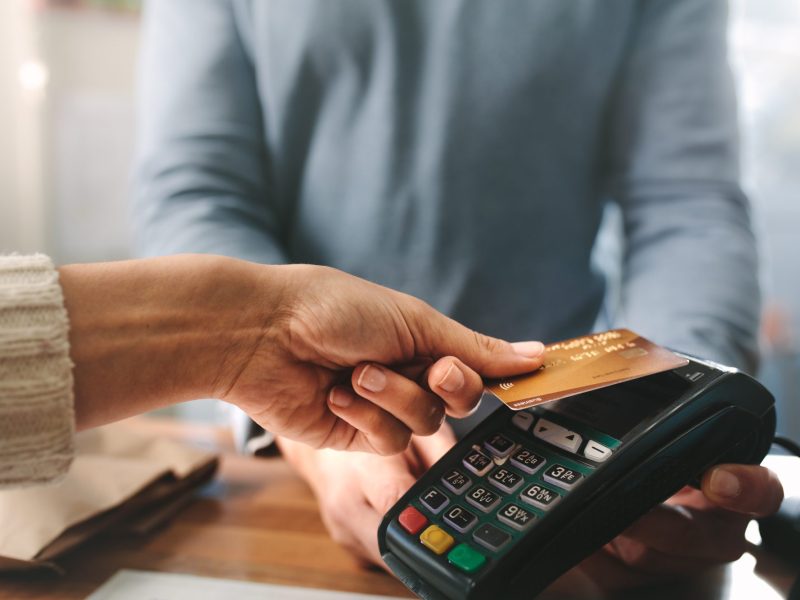 Frau drückt ihre Bankkarte auf ein Überweisungsgerät.