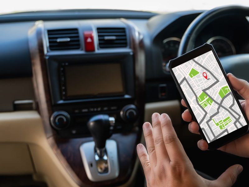 Mann benutzt GPS-Tracker im Auto.