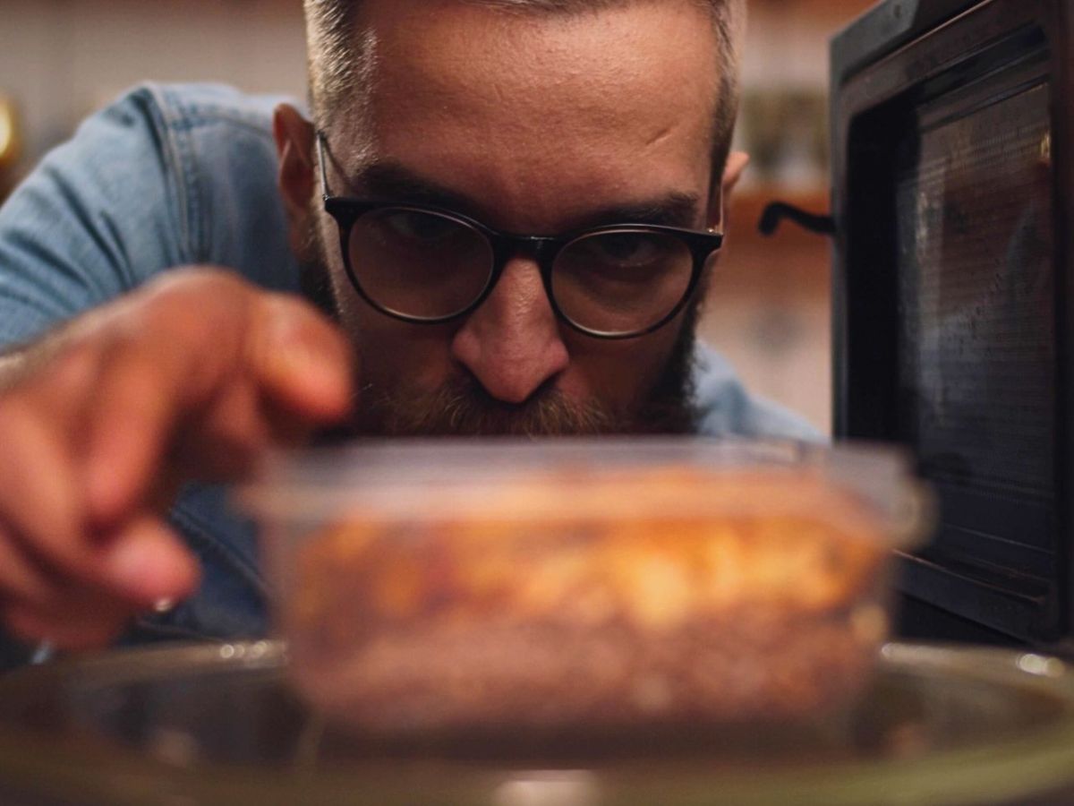 Mann stellt Essen in Mini-Mikrowelle
