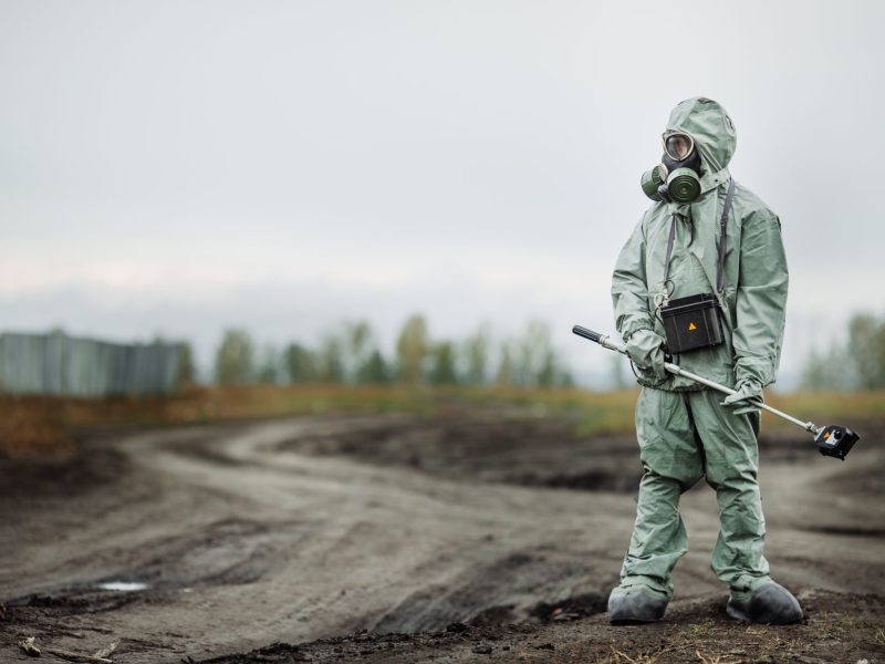 Person im Strahlenanzug steht auf ödem Gelände in Tschernobyl.