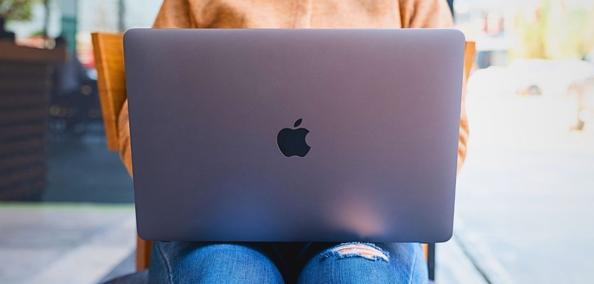 MacBook von Apple auf dem Schoß einer Frau.