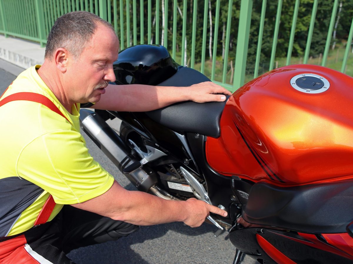 Mann führt den TÜV beim Motorrad durch.