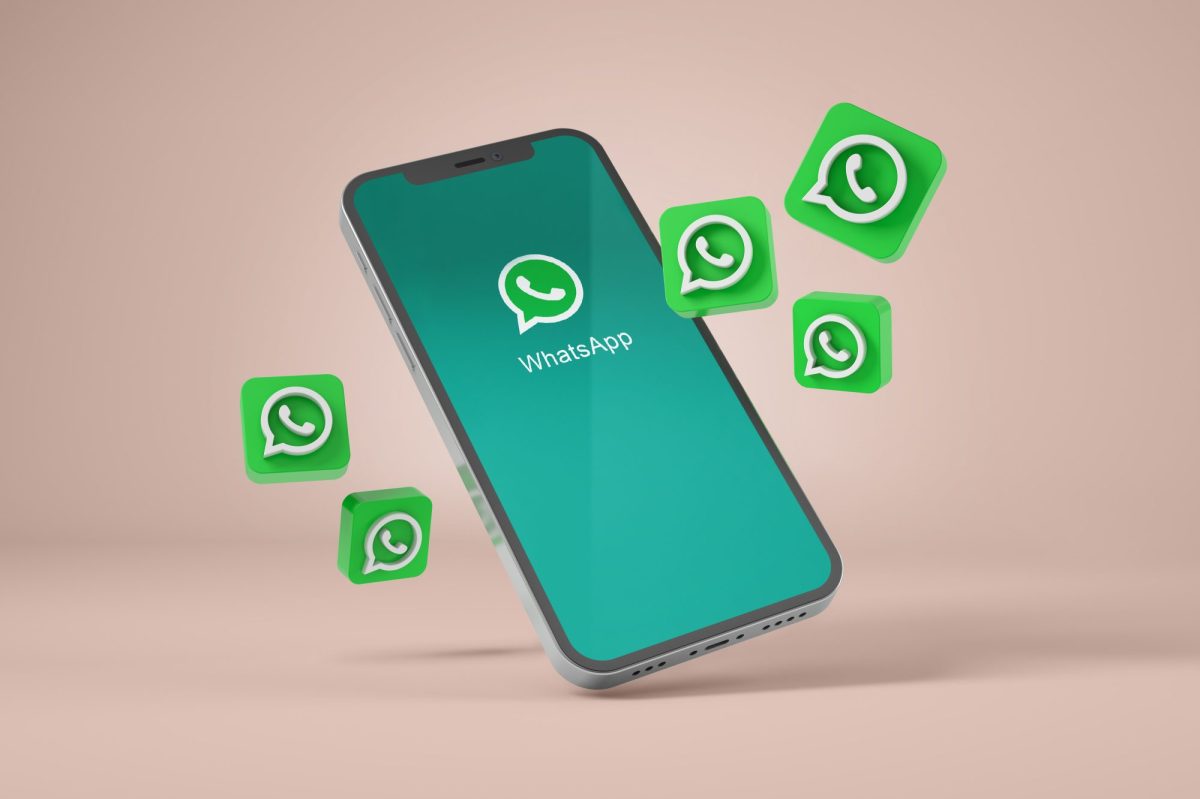 Handy mit WhatsApp-Symbolen umgeben.