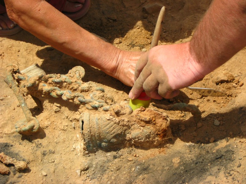 Forscher arbeiten mit Werkzeug an einem archäologischen Fund.