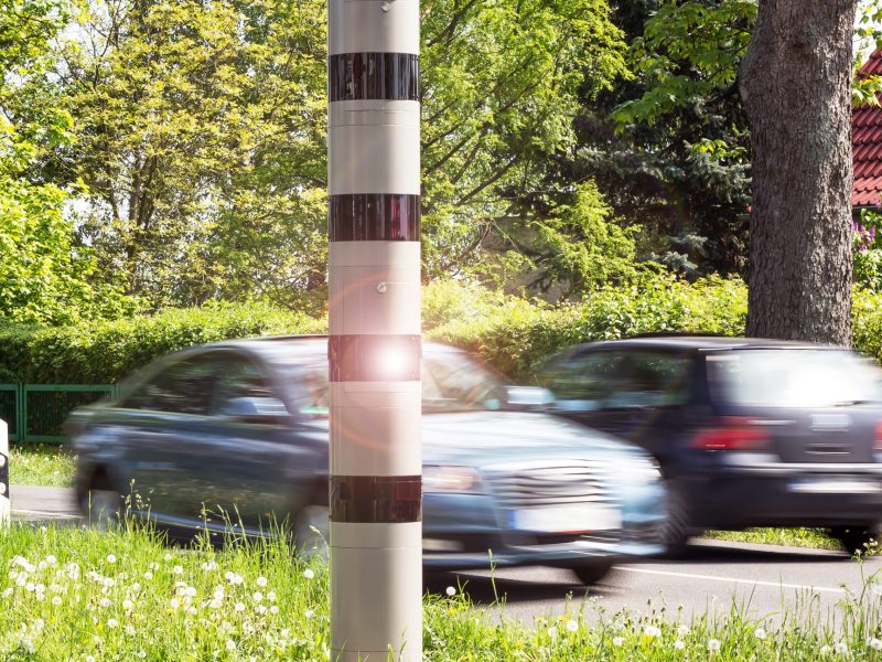 Eine Blitzersäule am Straßenrand.