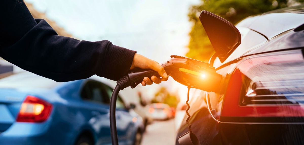 Person lädt ein Elektroauto