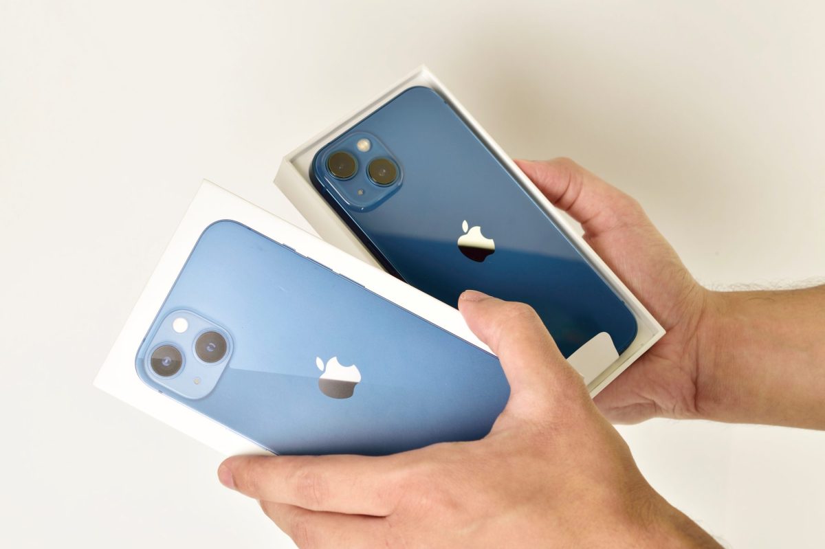 Eine Person hält ein iPhone in einer Verpackung in der Hand.