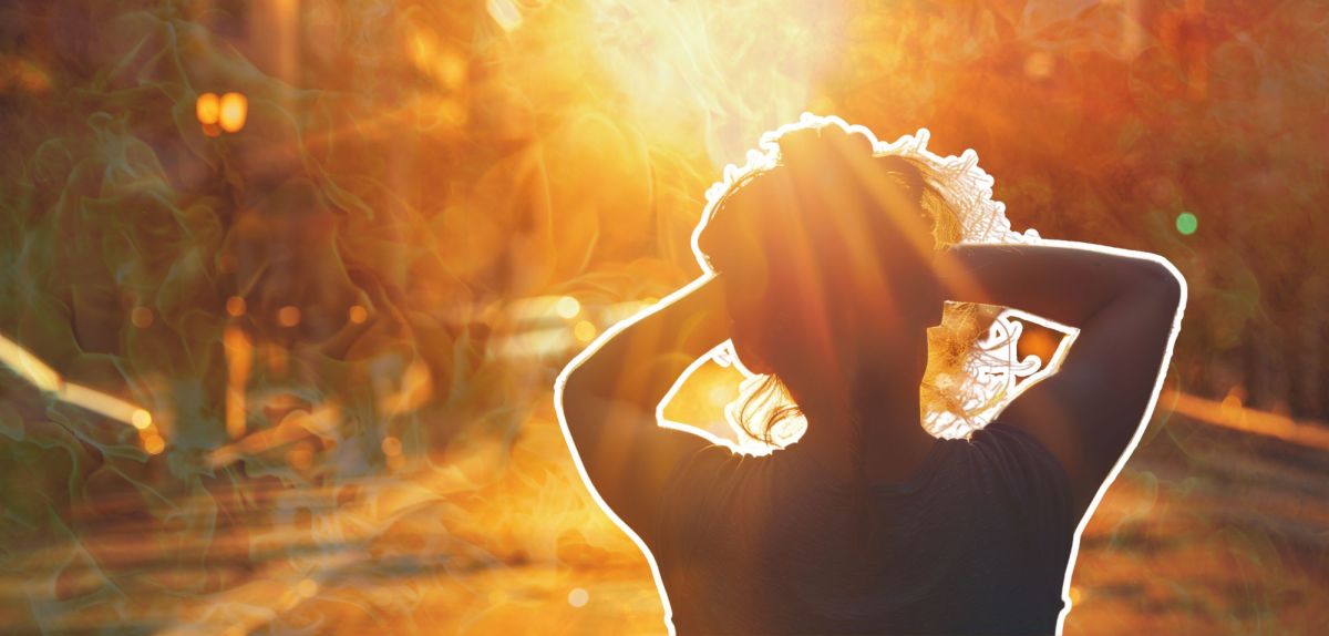 Frau hält sich, geblendet von der Sonne, die Hände über die Augen