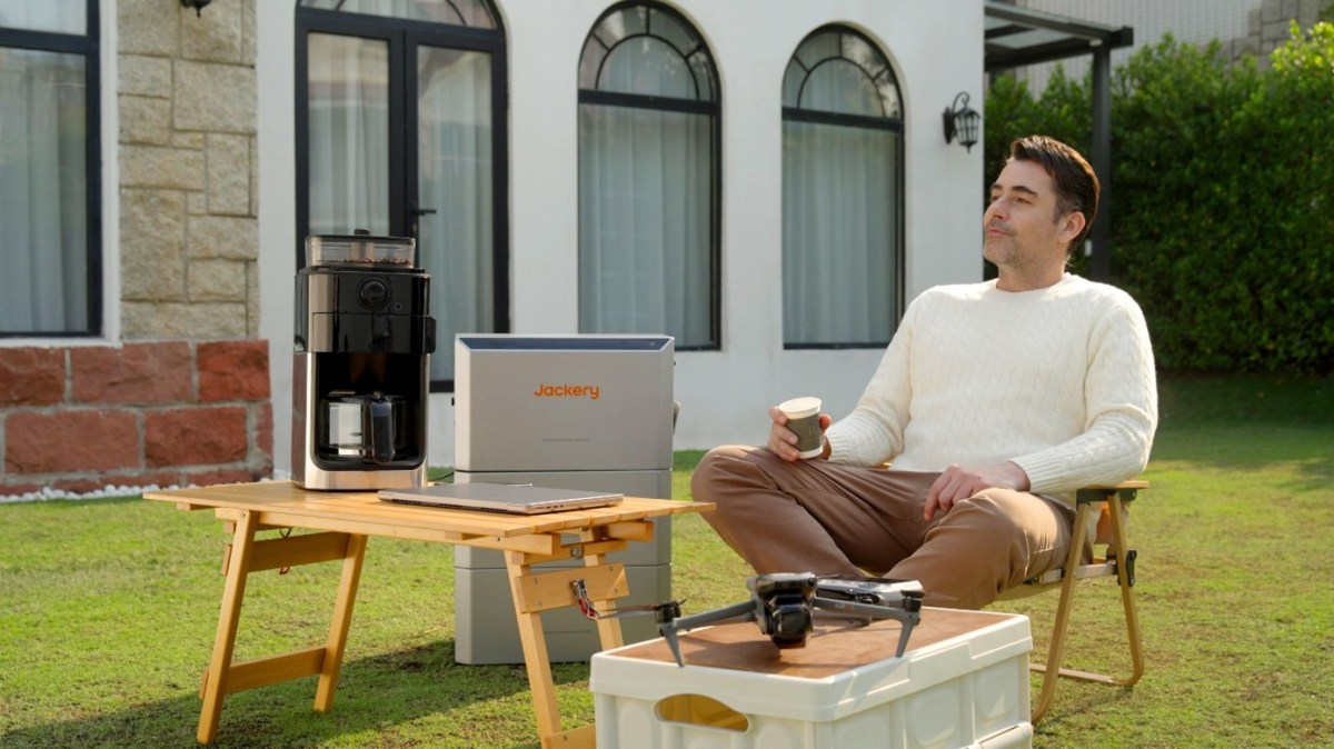 Mann sitzt neben einer Jackery HomePower 2000 Ultra im Garten