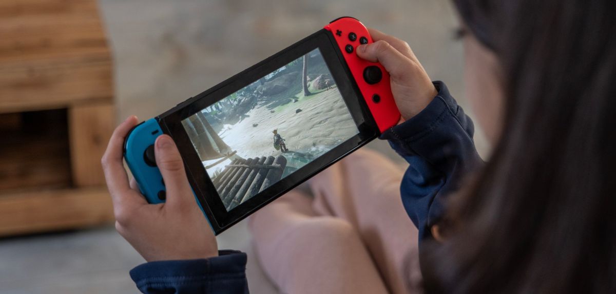 Person hält eine Nintendo Switch in den Händen.