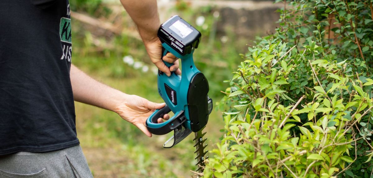 Person hält eine Makita Akku-Heckenschere in der Hand.
