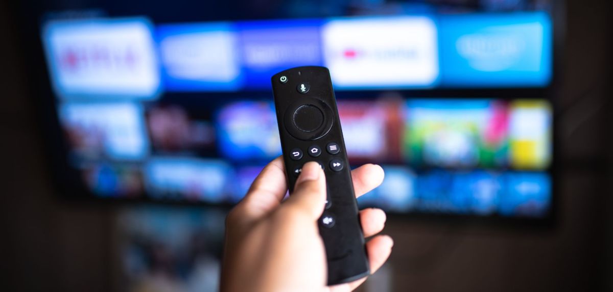Amazon Fire TV Stick wird auf einen Fernseher gerichtet.